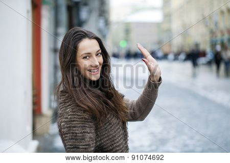 Young beautiful woman in stylish mink coat on a background of a winter street