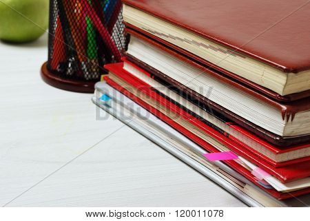 Group of school supplies, books, diaries, on a wooden table surfase. close-up photo