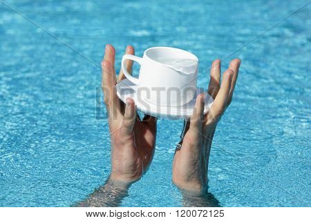 two hands saving a cup and saucer containing some valuable liquid as a symbol of addiction, great value

