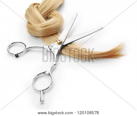 Hairdresser's scissors with strand of blonde hair, isolated on white
