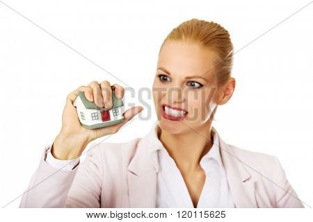 Aggresive business woman crushing small house