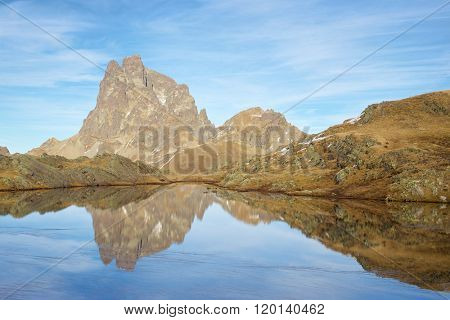 Midi Dossau Peak reflected in a lake. Ossau Valley, Pyrenees National Park, Pyrenees, France.