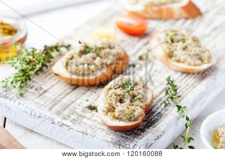Bruschetta with green olives paste, tapenade on a white wooden background