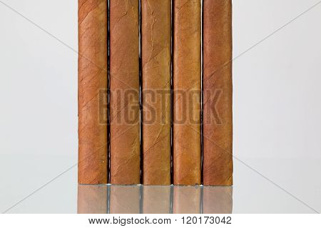 Different cigars on a glass table and white background