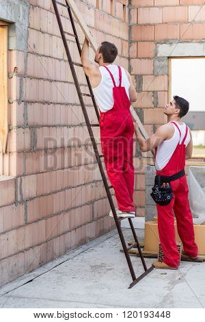 Workers Holding Wooden Balk