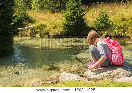 Cute little girl of 7-8 years old hiking in swiss Alps