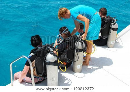 The woman diving coach gives instructions to beginners before diving from the boat, red sea