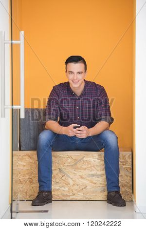 young man in crative box working on smart phone, startup business modern office room  interior