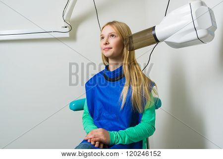 Dentist hands make jaw x-ray image for little girl in dental clinic