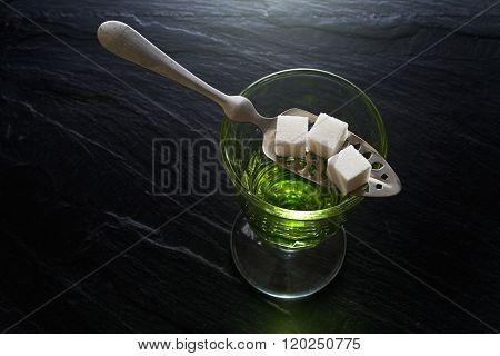 absinthe in pontarlier glass and spoon with sugar cubes