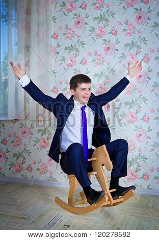 Childish businessman with toy horse
