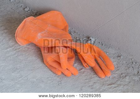 Two Orange Rubber Gloves On Concrete Flloor