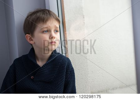 Sad 7 Years Boy Child Looking Out The Window.