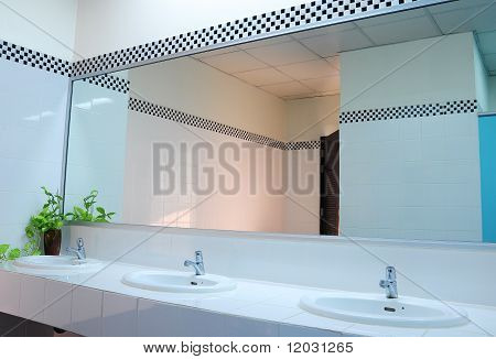 Bagno in ufficio.Lavabo e specchio in bagno