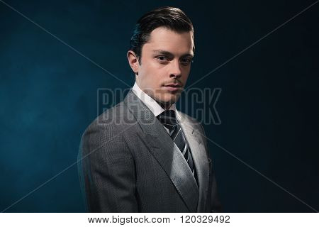 Retro 1940S Business Man In Suit And Tie Against Blue Wall.