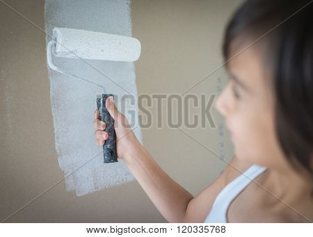 Little cute boy painting on a wall