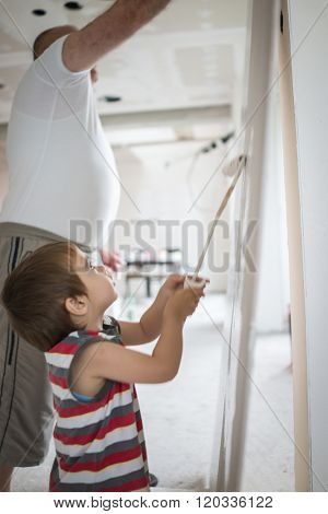 Little cute boy painting on a wall