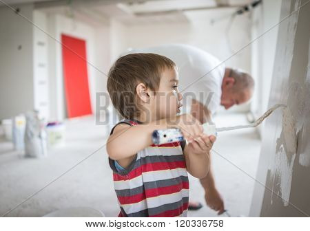 Little cute boy painting on a wall