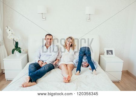 Happy Family In Bedroom.a Pregnant Woman