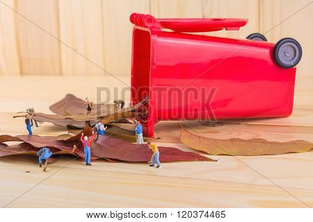 Image Of Mini Figure Dolls Worker Collect Dry Leaves Into The Red Recycle Bin .