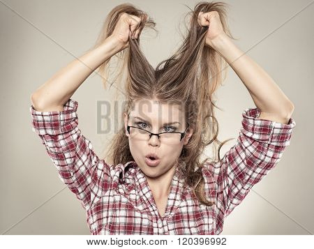 Young crazy business woman with disheveled hair and squint eyes