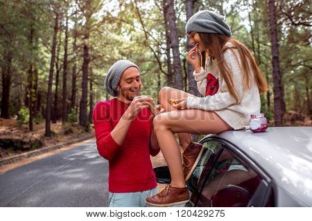 Young couple traveling by car in the forest