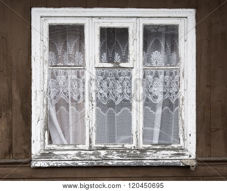 Closed old window with curtain.