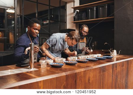 Baristas training in a modern roastery with varieties of coffee