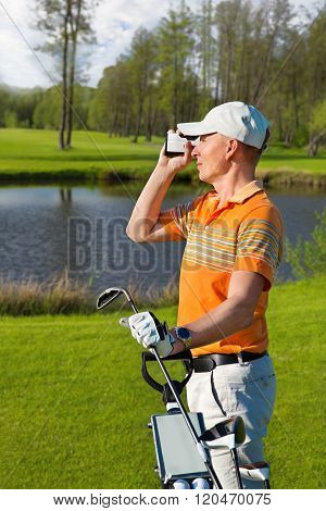 man golfer watching into rangefinder
