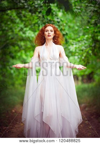 Beautiful Redhead Woman Wearing White Dress In A Forest
