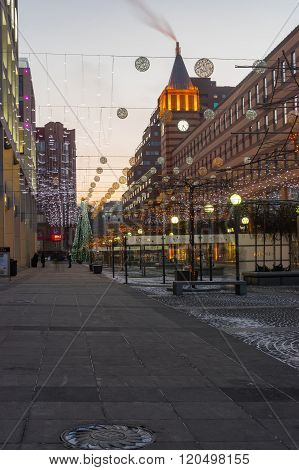 Empty square with evening illumination and occasional passers-by