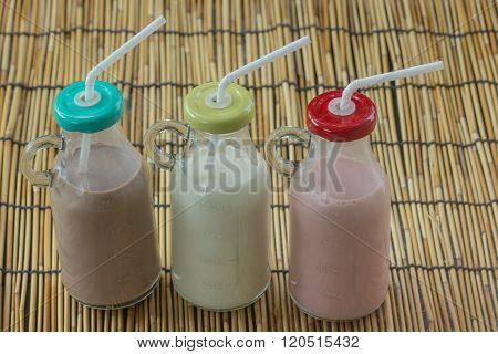 Strawberry chocolate and fresh milk bottles on garden background