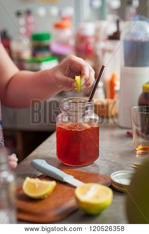 The process of making Thai lemon tea. Woman left hand squeeze lemon into cold tea