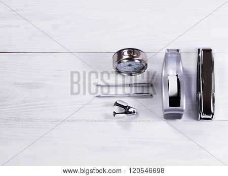 Stainless Steel Stationery Objects On White Wood Background