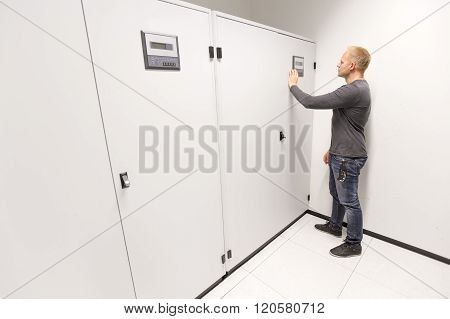 IT engineer adjusts air conditioner in datacenter