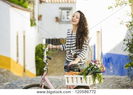 Beautiful female tourist living like a local, with her bicycle after buying some fresh vegetables