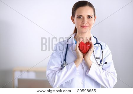 Female doctor with stethoscope holding heart