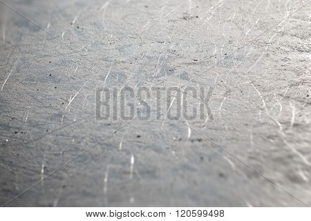 Bad ice at the city rink in sunny spring day. Many bands, cuts, cracks