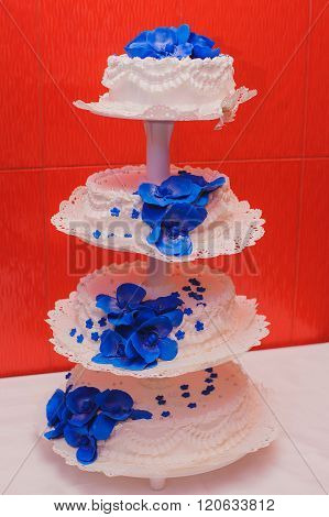 Beautiful and natural four level wedding cake with blue flowers.