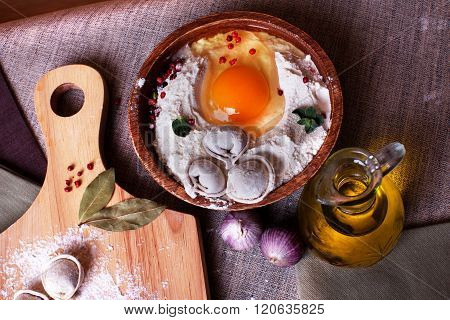 hand-made dumplings on the board with flour and ingredients garlic board flax bay leaves on top a beautiful still-life 