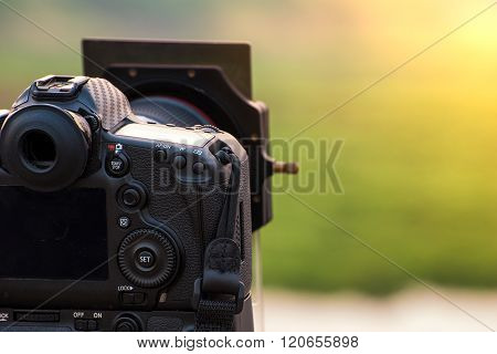 DSLR camera with gradient filter focus on sunrise landscape view.