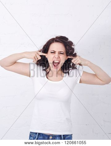 Girl Screams, Covering Ears With Her Hands.