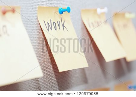 Adhesive note with Work text on a bulletin board