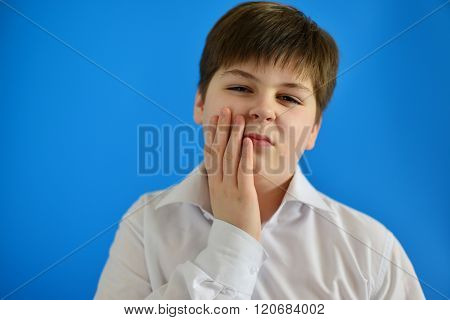 Teenage boy with a toothache on light background