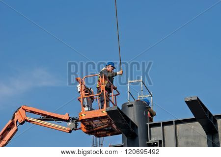 Belgrade Serbia - February 27 2016: Construction worker on a raised platform puts the reinforcement of the pillars of the building
