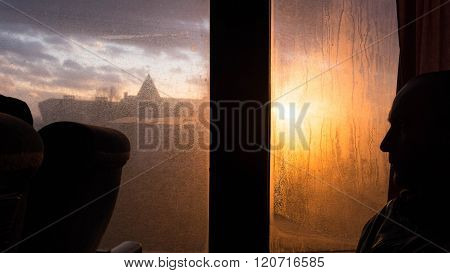 Man Looks Through The Steamed Window Of Bus To The Foggy  And Rai