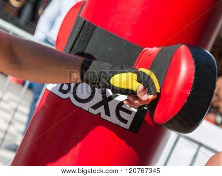 Close Up Of Young Man With Boxing Glove In Fitness Class With Red Punching Bag