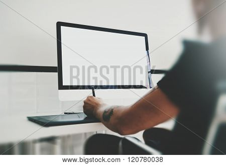 Man working at workspace with generic design computer on the table. Blank screen desktop. Horizontal