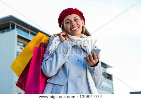 Girl using at her phone during shopping outisde