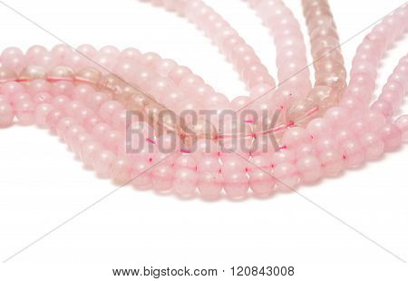 Strings of pink quartz for making jewellery on white background
** Note: Soft Focus at 100%, best at smaller sizes